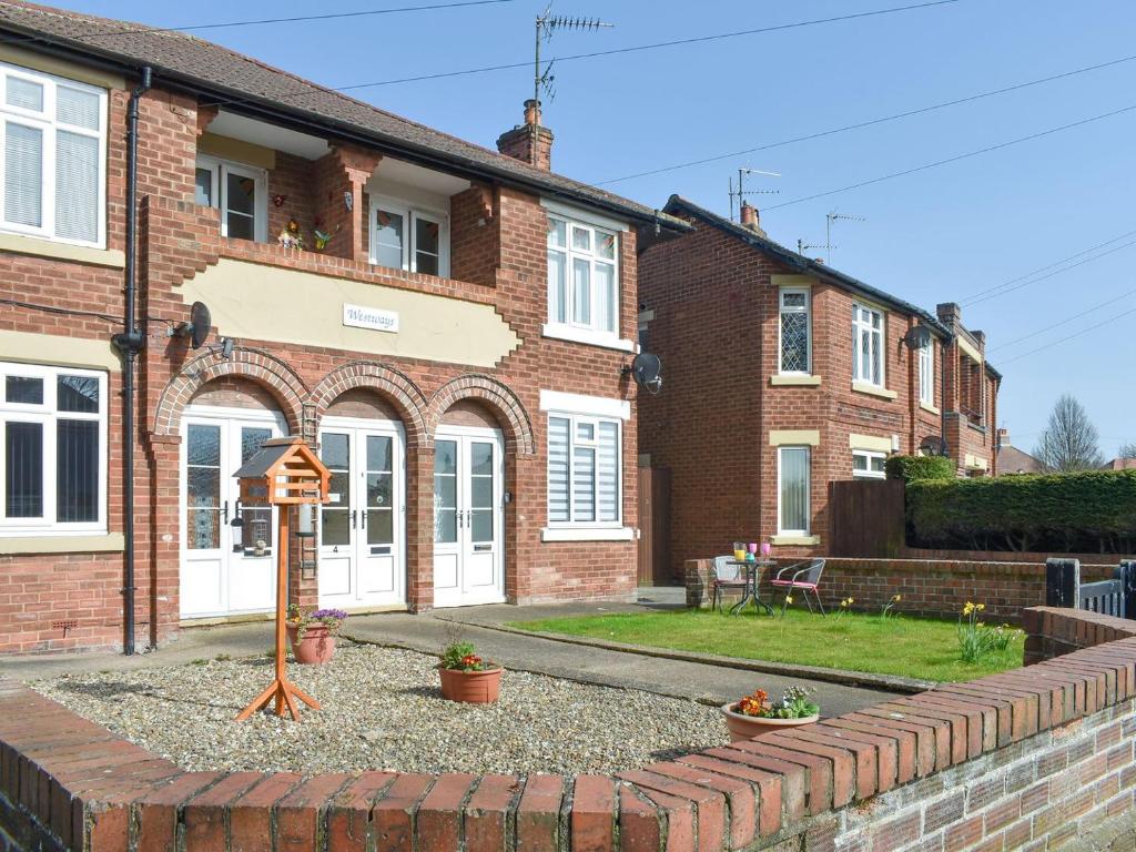 a brick house with a sign in front of it at Westways in Bridlington