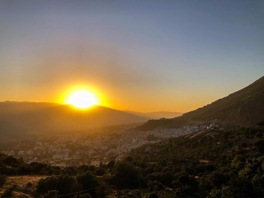 a view of the sun setting over a city at Blue House Town in Chefchaouen