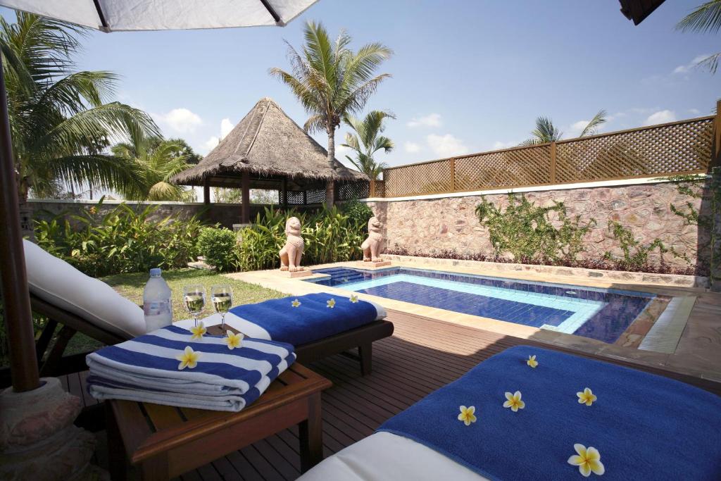 a resort with a swimming pool with blue cushions at Palace Residence & Villa Siem Reap in Siem Reap