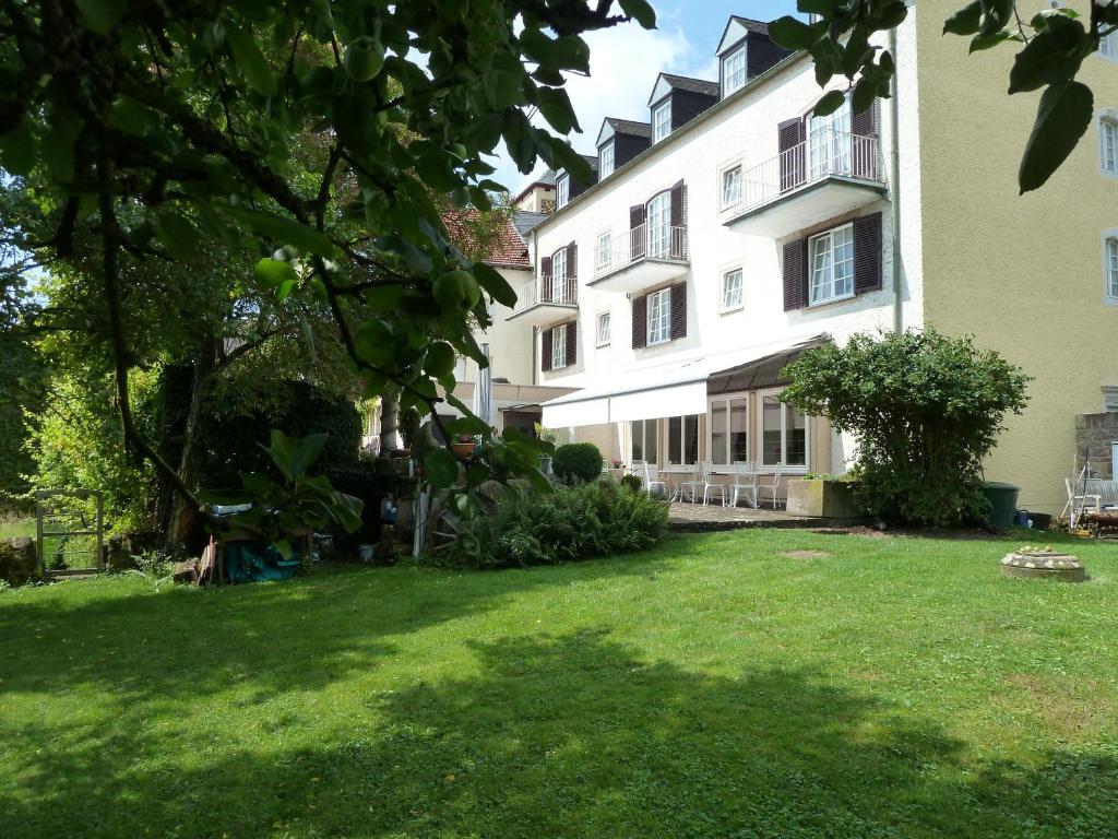 un grand bâtiment blanc avec une pelouse dans l'établissement Hotel zum alten Brauhaus, à Dudeldorf