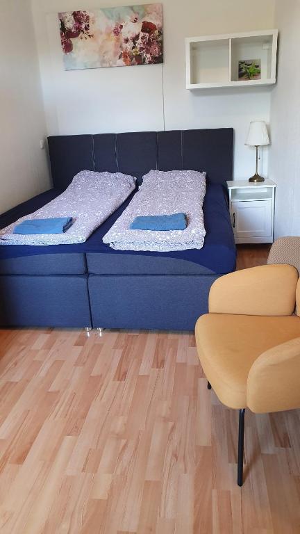 een blauw bed in een kamer met een houten vloer bij Ferienwohnung 2 in Glindow