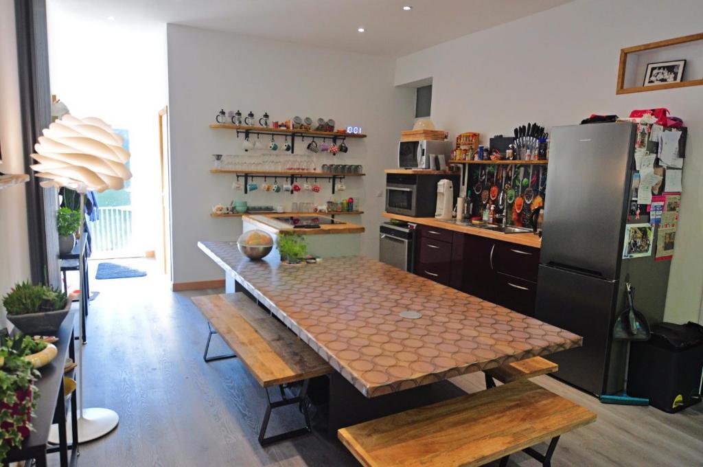 a kitchen with a table and a refrigerator at La coulée pilette in Callac