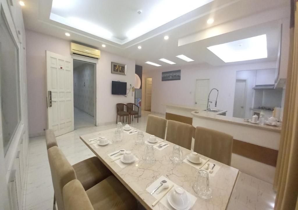 uma sala de jantar com mesa e cadeiras e uma cozinha em Khai Hoan Apartment Hotel em Ho Chi Minh