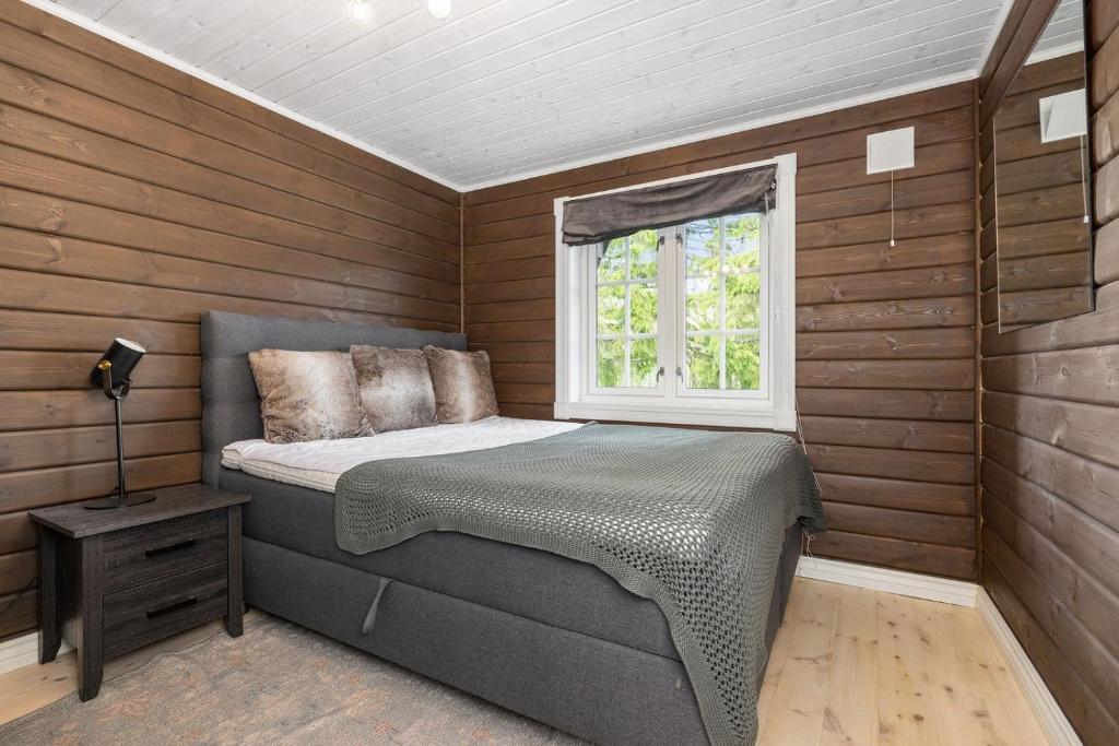 a small bedroom with a bed and a window at Libeli- panoramaview towards Gaustadtoppen- Jacuzzi in Lona