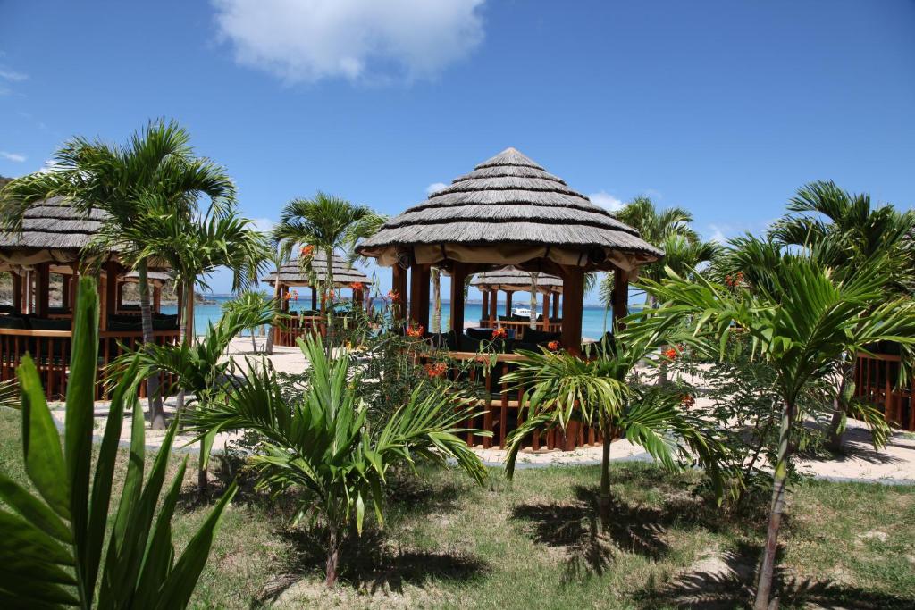 a resort with two gazebos and palm trees at Le Domaine Anse Marcel Beach Resort in Anse Marcel 