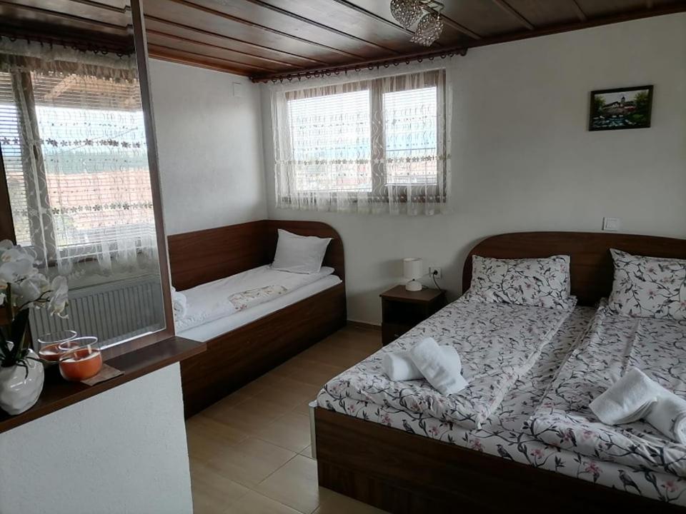 a bedroom with a bed and a window at Къща за гости Градината in Dobrinishte