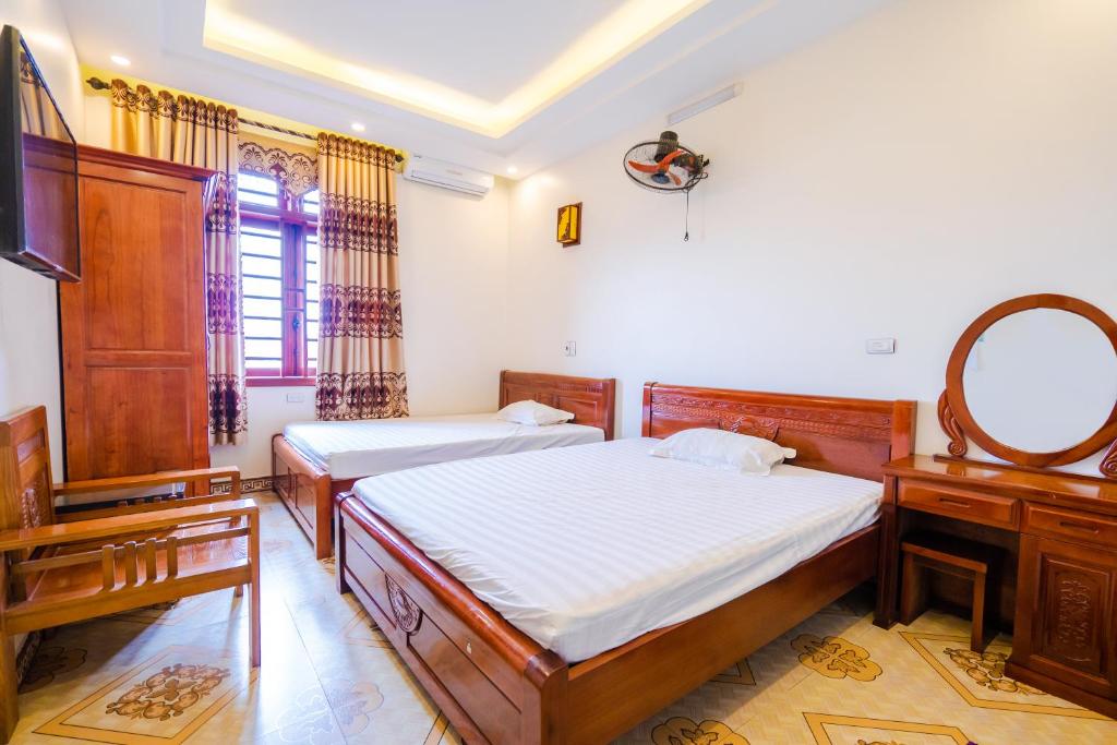 - une chambre avec 2 lits et un miroir dans l'établissement Nhà Nghỉ Xuân Mai, à Lạng Sơn
