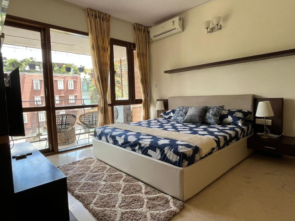 a bedroom with a bed and a large window at LUHO Grande in Bangalore
