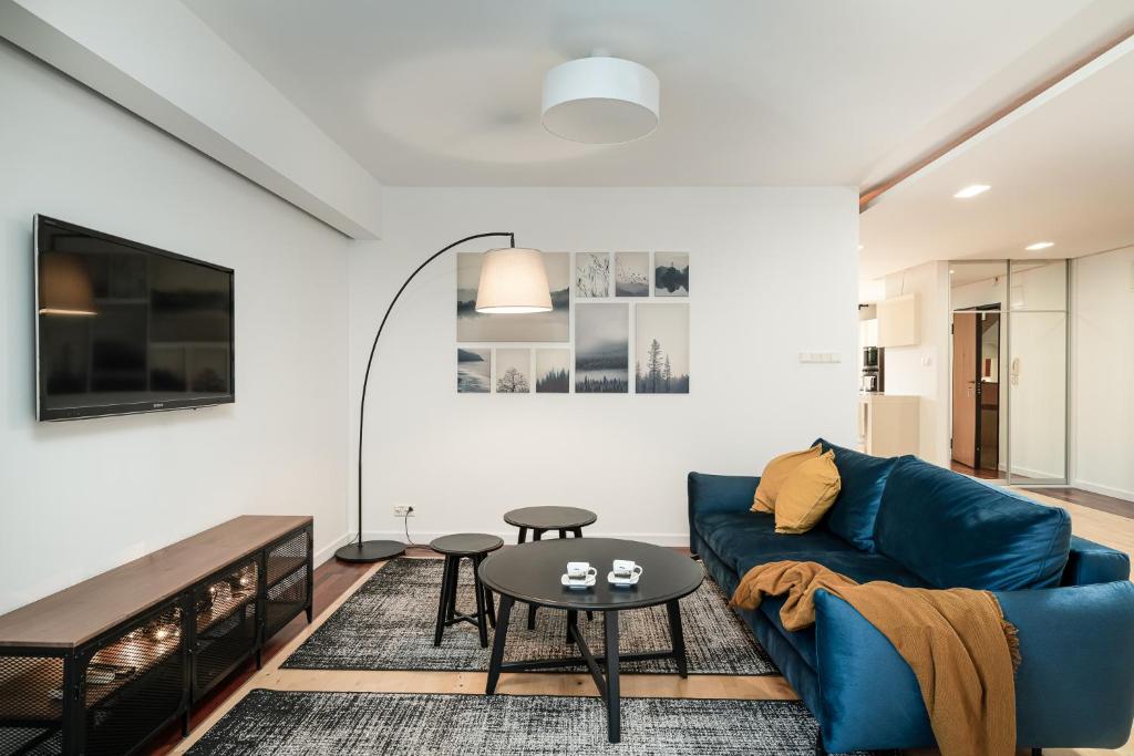 a living room with a blue couch and a table at LeoApart in Wrocław