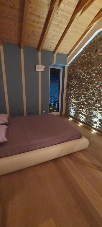 Bett in einem Zimmer mit einer Steinmauer in der Unterkunft Duplex in Cuneo