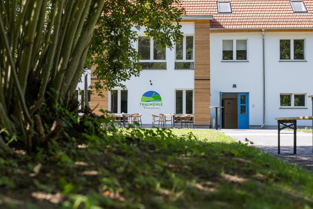 a building with tables and chairs in front of it at Thalmühle in Meisdorf