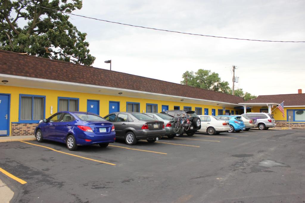 a group of cars parked in a parking lot in front of a building at Scottish Inns Sparta in Sparta