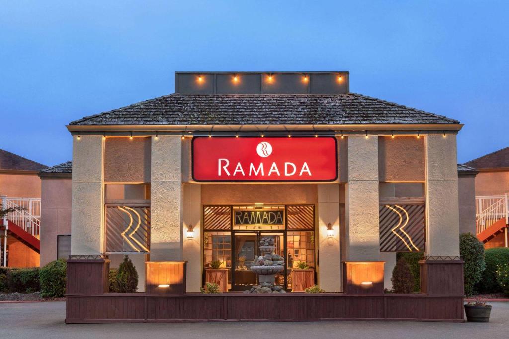 a ramada building with a red sign on it at Ramada by Wyndham Arcata in Arcata