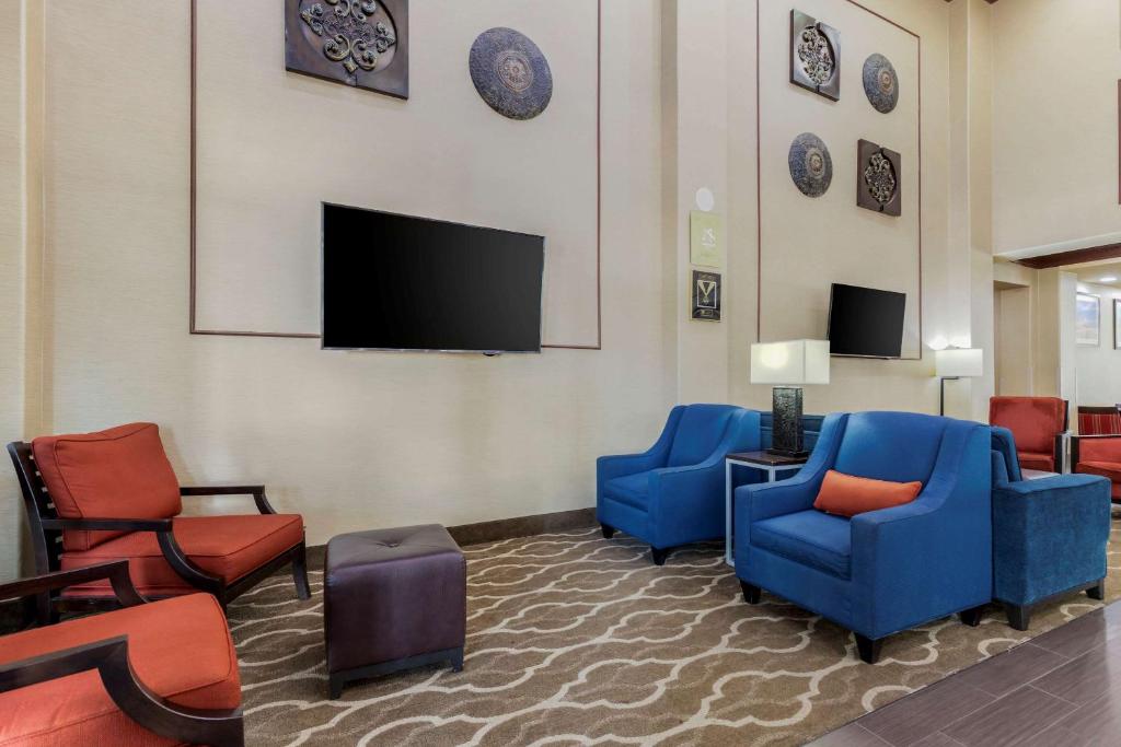 een wachtkamer met blauwe stoelen en een flatscreen-tv bij Comfort Suites Pflugerville - Austin North in Pflugerville