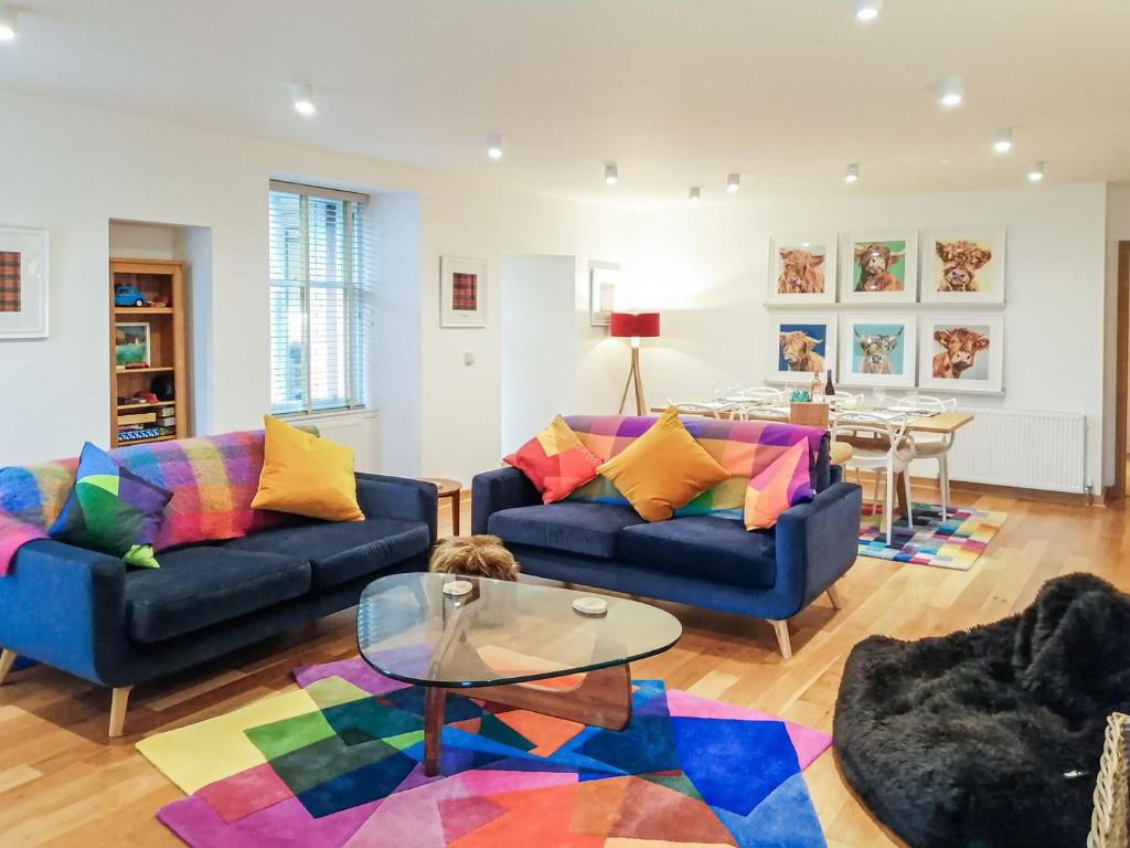 a living room with two couches and a table at Kilbowie Retreat in Oban