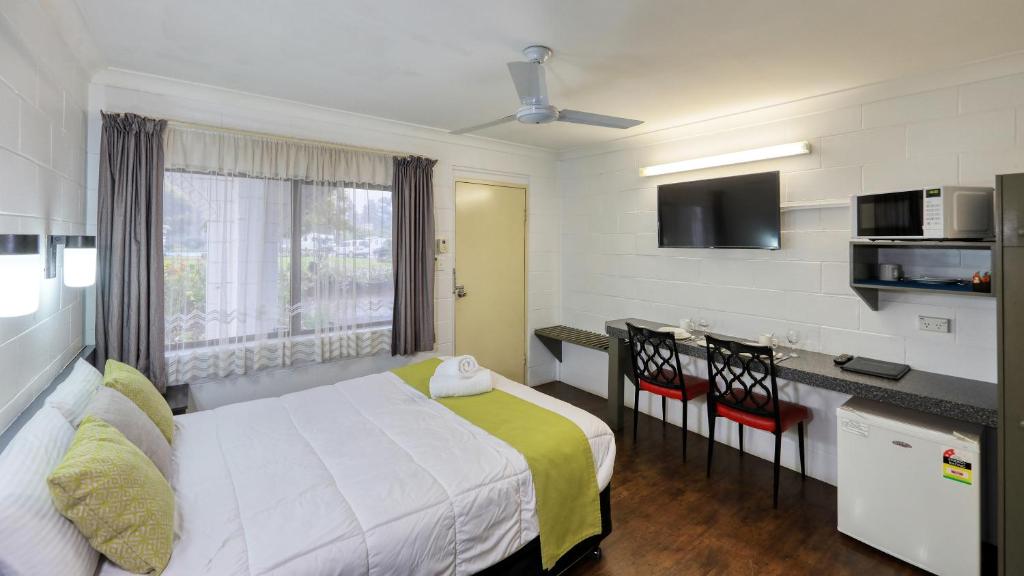 a hotel room with a bed and a desk and a kitchen at Azalea Motel in Coonabarabran