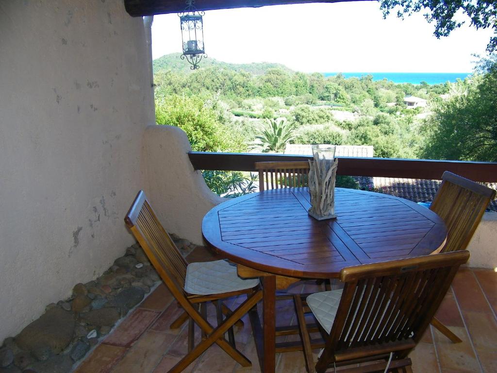 uma mesa de madeira e cadeiras numa varanda em Mini Villa St-Lucie Porto-Vecchio vue mer 5mnplage em Zonza