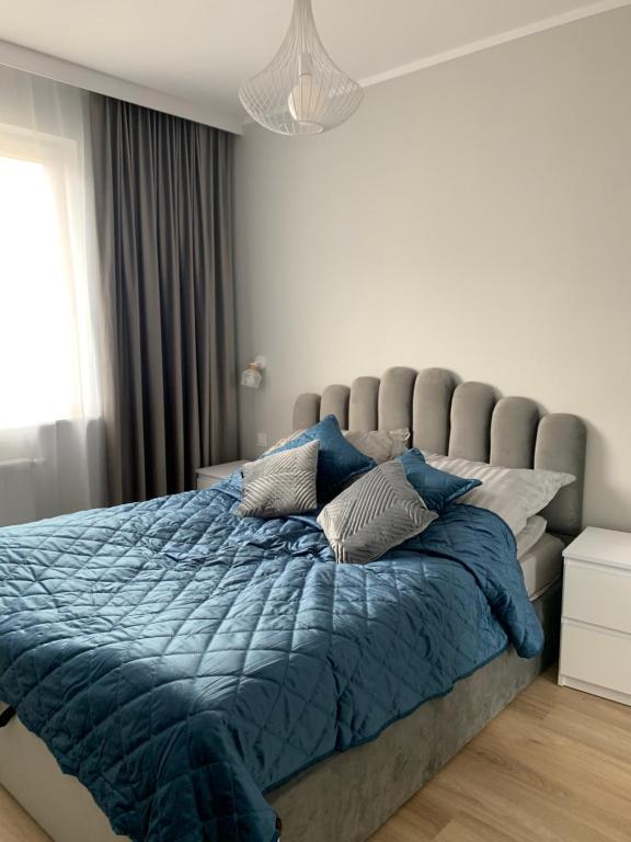 sypialnia z dużym łóżkiem z niebieską kołdrą w obiekcie Platinum De Lux Apartament w mieście Stargard