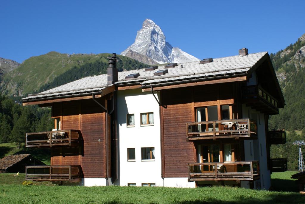 a large building with a mountain in the background at Haus Galileo in Zermatt