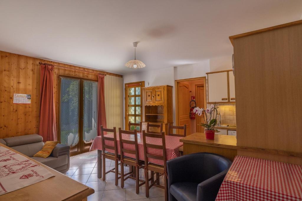 uma cozinha e sala de estar com mesa e cadeiras em Le petit chez soi em Châtel