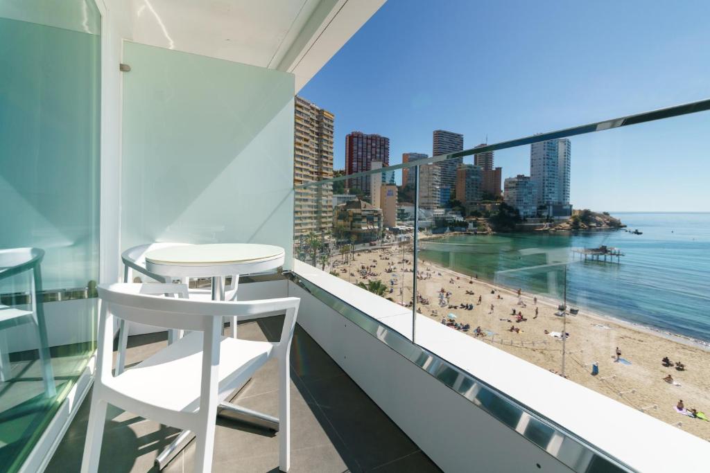 a balcony with a white stool and a view of the beach at Hotel Brisa in Benidorm
