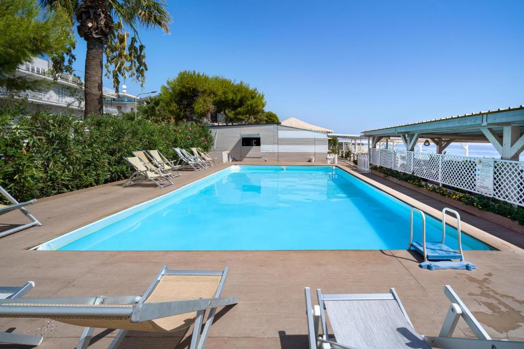 a large swimming pool with lounge chairs at Hotel Rivage Taormina in Taormina