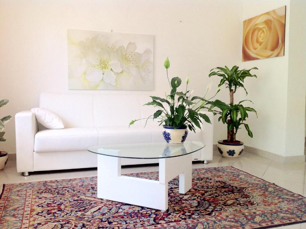 a living room with a white couch and a table at Residence Villa Ofelia in Rimini