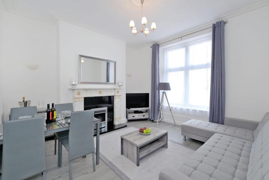 a white living room with a couch and a table at Orange Apartments Union Grove in Aberdeen