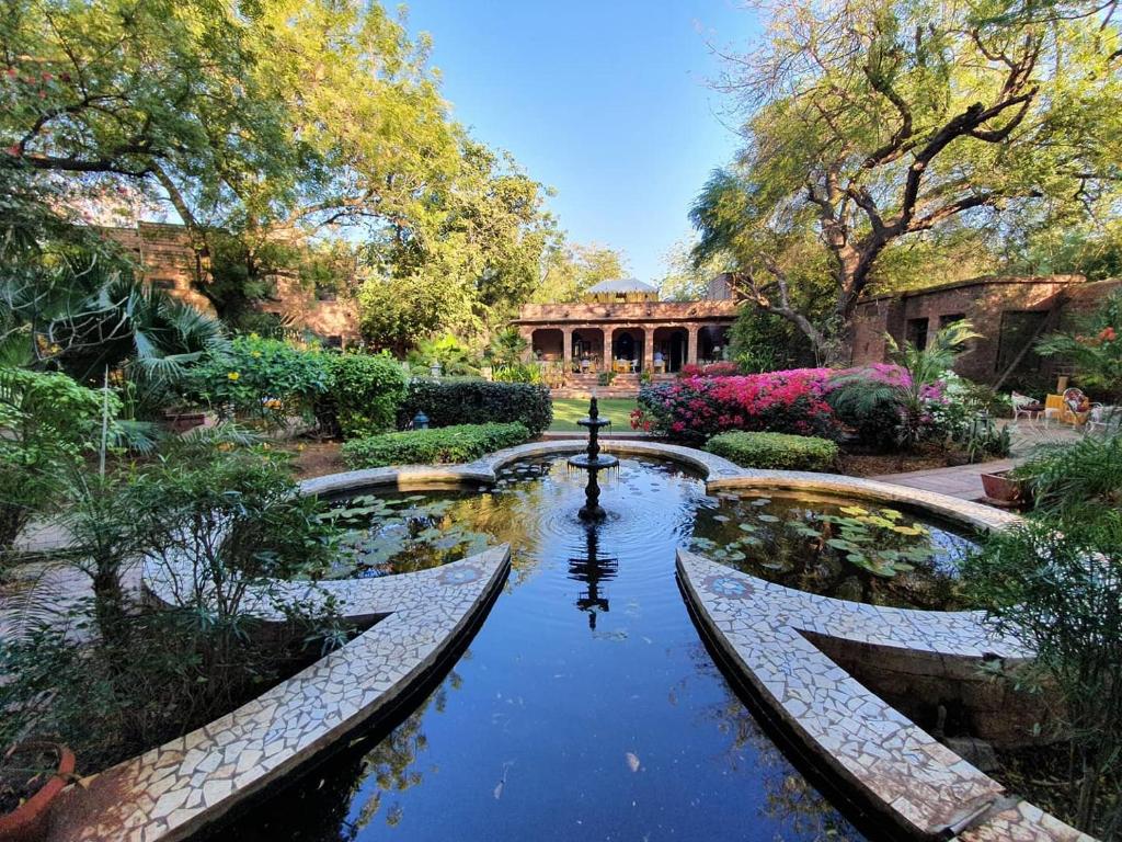 un étang au milieu d'un jardin dans l'établissement Devi Bhawan - A Heritage Hotel, à Jodhpur