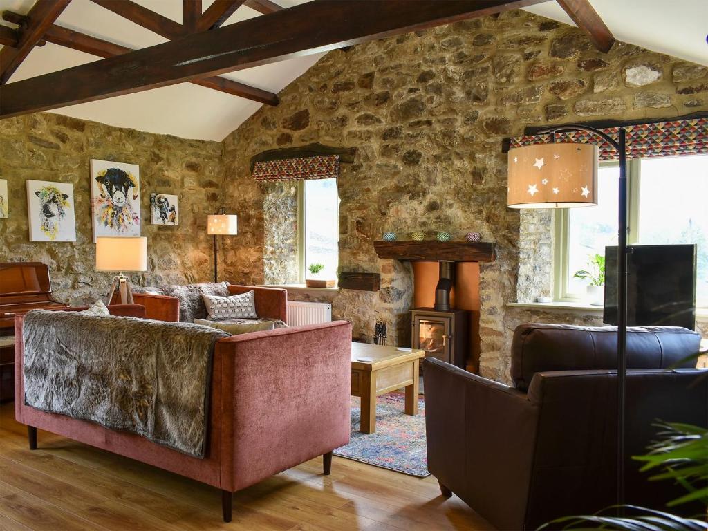 a living room with a stone wall at The Well House in Starbotton