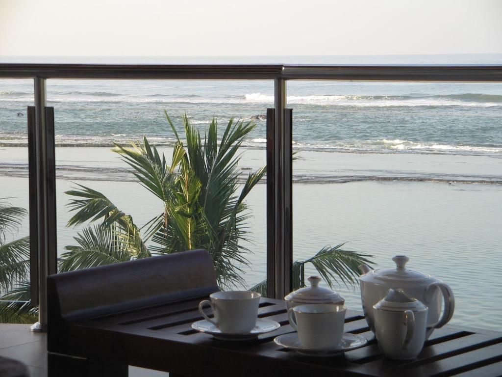 a table with two tea cups and a view of the beach at Paradise Bay in Beruwala