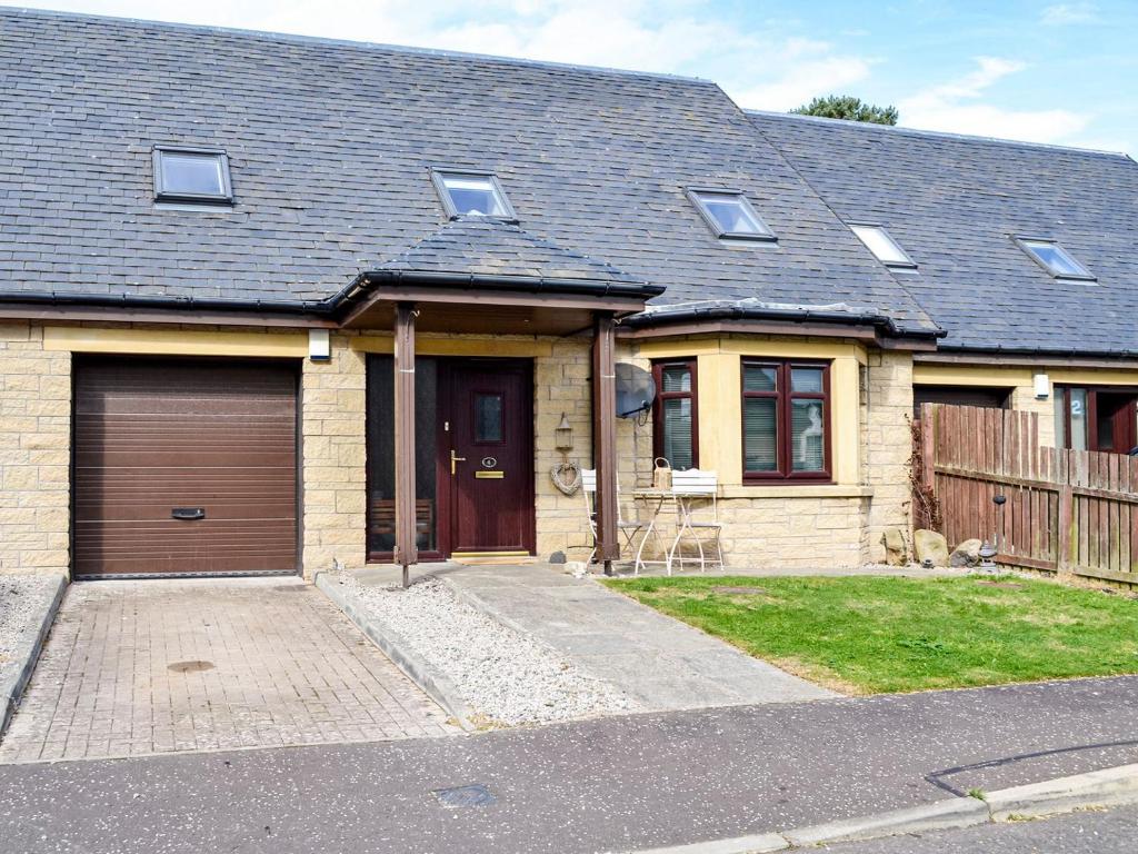a brick house with a garage at Fiddlers Retreat in Monikie