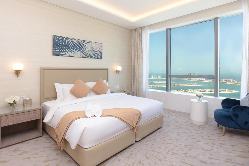 Luxury Living & Views -St Regis High Floor Suite 4 by Exclusive Holiday Homes في دبي: غرفة نوم بسرير كبير ونافذة كبيرة