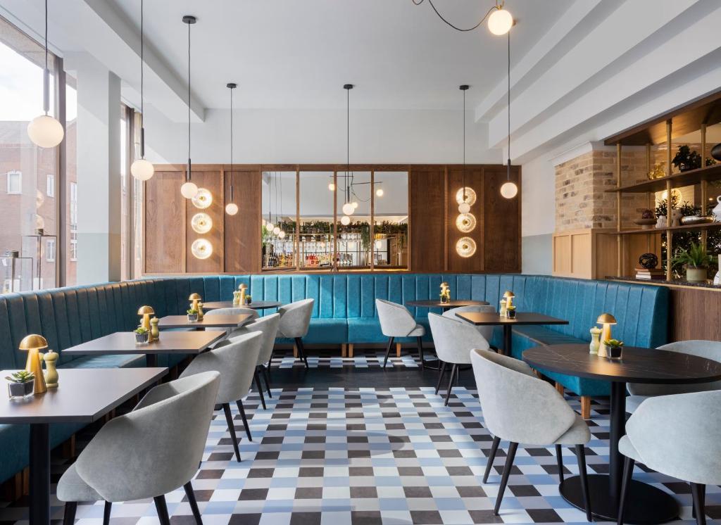 a restaurant with tables and chairs and a checkered floor at Leonardo Royal Hotel Birmingham in Birmingham