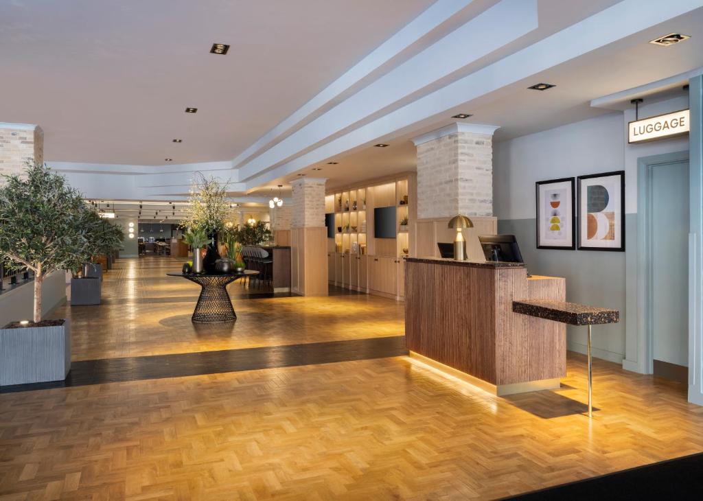 a lobby with a reception desk in a building at Leonardo Royal Hotel Birmingham in Birmingham