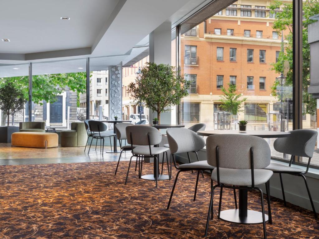 a large room with chairs and tables and windows at Leonardo Royal Hotel Birmingham in Birmingham