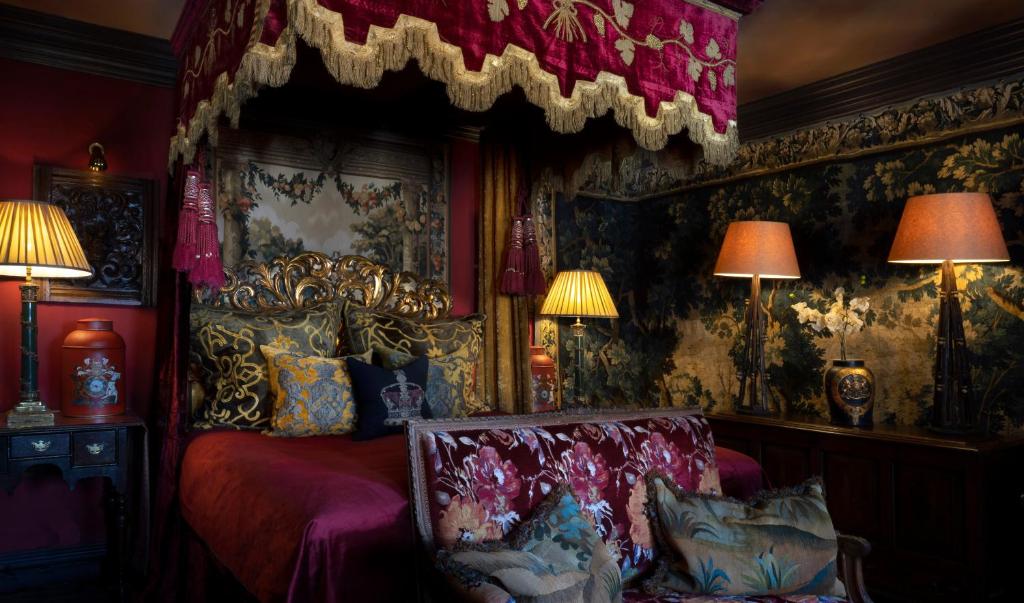 a room with a bed, a lamp, and a painting on the wall at The Witchery by the Castle in Edinburgh