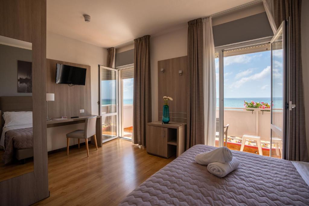 a hotel room with a bed and a view of the ocean at Hotel Loreley in Lido di Jesolo