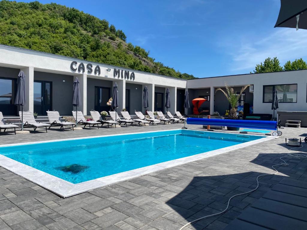 ein Hotel mit einem Pool und Liegestühlen in der Unterkunft Casa Mina Divici in Divici