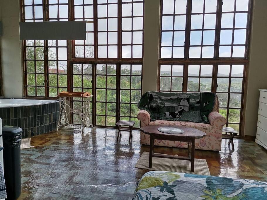 un soggiorno con divano, vasca e finestre di Windygates Estate Rustic Window Cottage a Thornhill