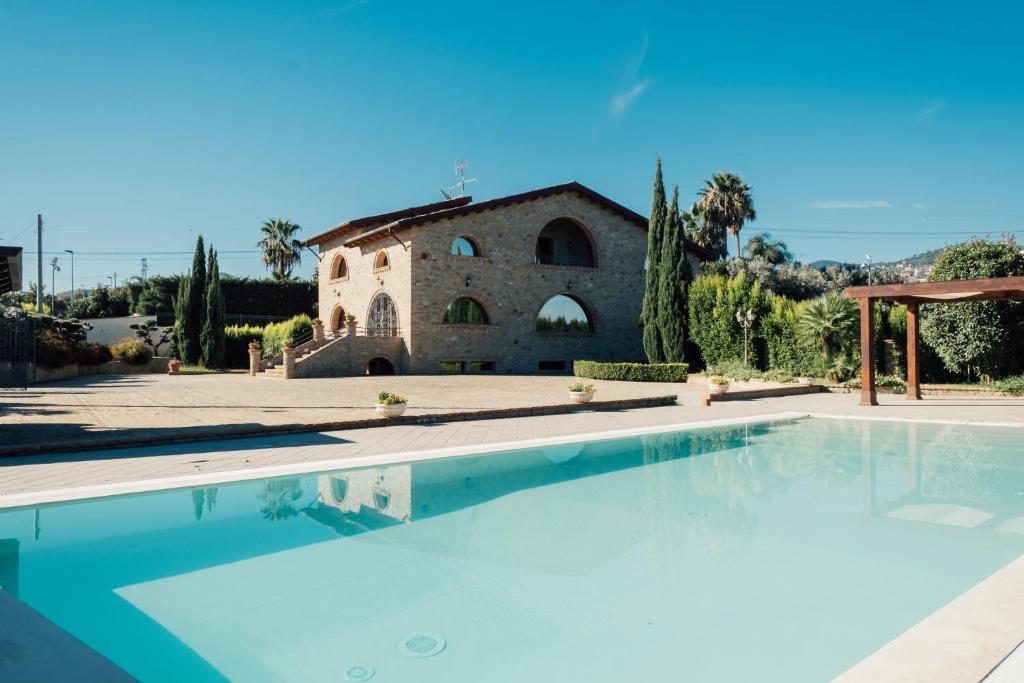 a villa with a swimming pool in front of a building at Tenuta Un Posto Al Sole Luxury B&B in Rossano Stazione