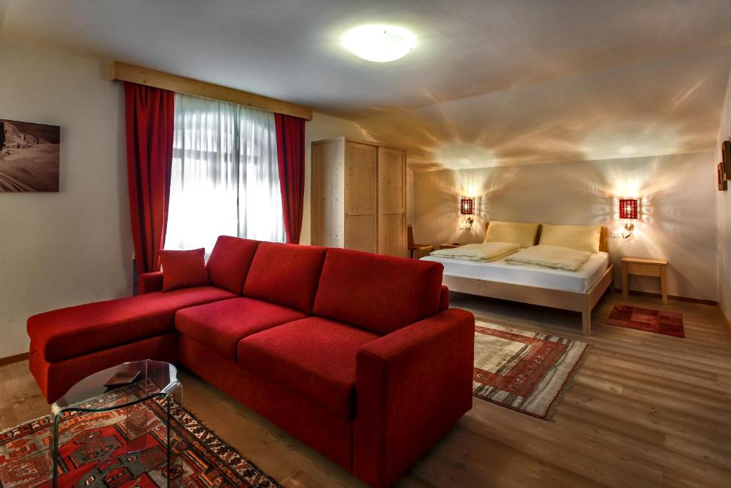 a living room filled with furniture and a red couch at Garni B&B Am Schloss in Brunico