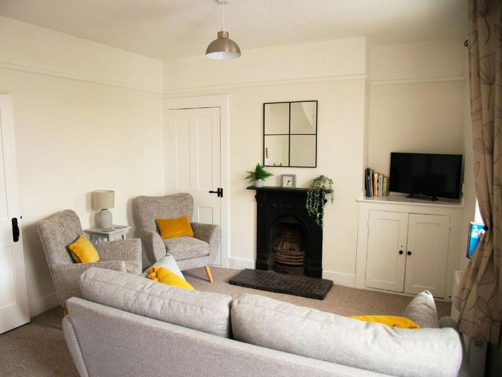 a living room with a couch and a fireplace at Pebble Cottage in Felpham