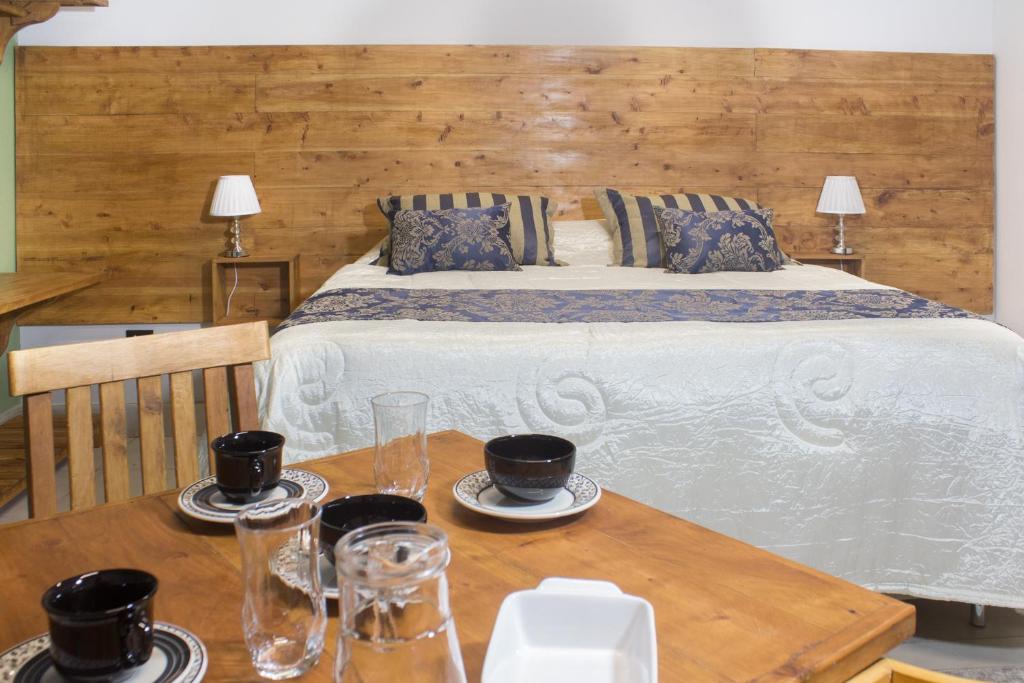 聖安東尼奧－杜皮尼亞爾的住宿－Vertentes da Mantiqueira，一间卧室配有床和桌子,上面有杯子