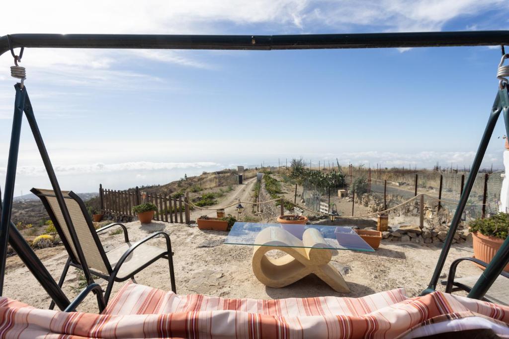 uitzicht vanaf een patio met een tafel en stoelen bij Casa Cueva Gaspara in Lomo de Arico
