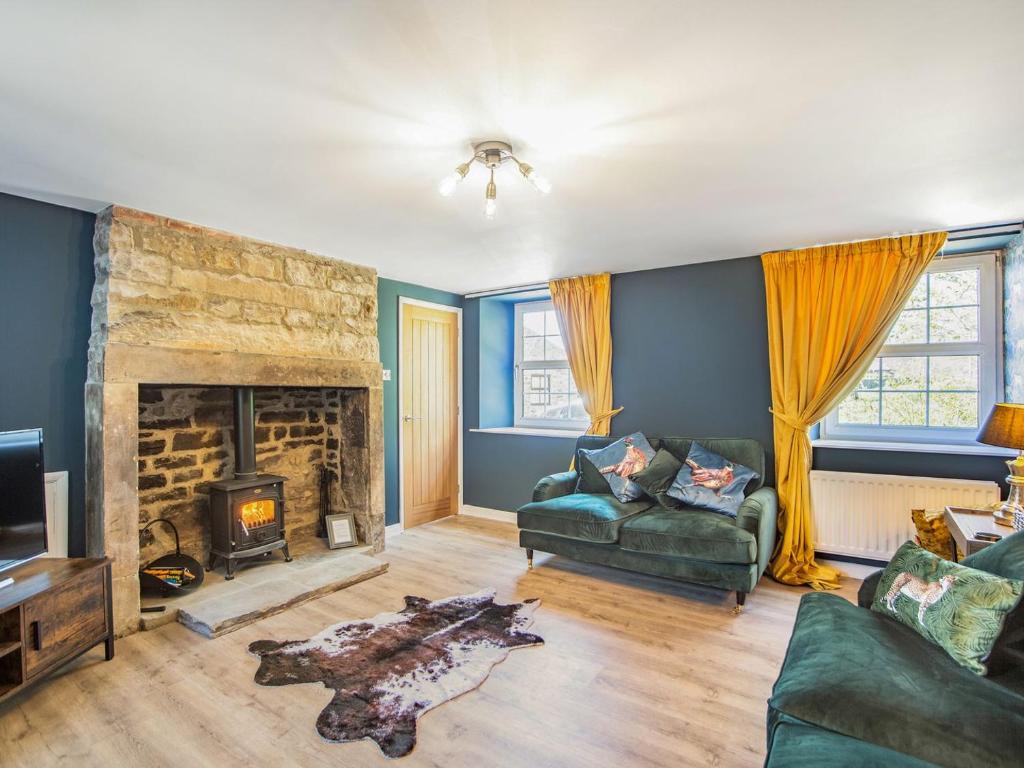 a living room with a couch and a fireplace at Hillside Cottage in Haltwhistle
