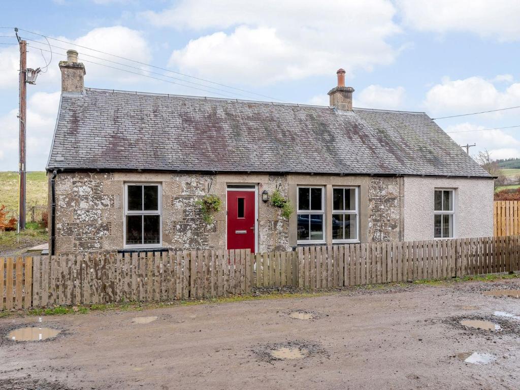an old stone house with a red door at Great Whaup in Culter