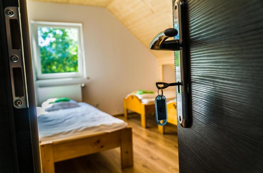 Habitación pequeña con cama y nevera negra. en Pokoje nad Przełomem Dunajca - Wietrznice - Rivent Sport en Łącko