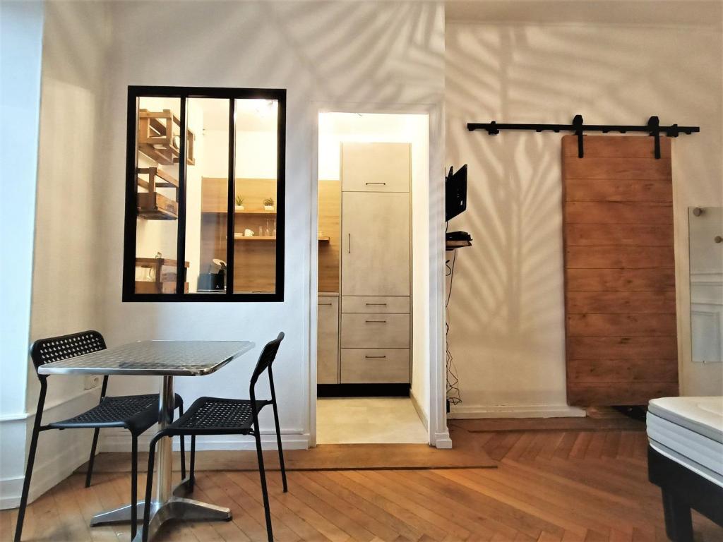 a room with a table and chairs and a mirror at Studio décoré et confortable avec balcon - Proche centre et Parc Floral, idéal pour 1-2 pers. - FR-1-555-59 in Aix-les-Bains