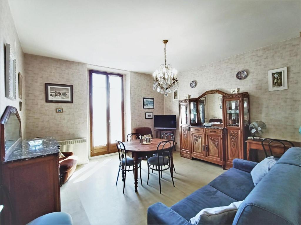 uma sala de estar com um sofá azul e uma mesa em Appartement Aix-les-Bains, 2 pièces, 2 personnes - FR-1-555-48 em Aix-les-Bains